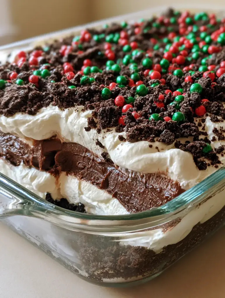 No-Bake Christmas Oreo Lasagna: The Ultimate Holiday Layered Dessert 1 Overhead view of No-Bake Christmas Oreo Lasagna topped with coarse cookie crumbs and red and green sprinkles.