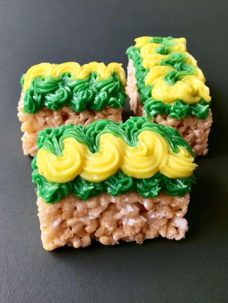 Glow in the Dark Rice Krispie Treats with Vibrant Neon Drizzles 1 Overhead shot of fluorescent yellow and green icing on rectangular cereal treats. (Glow in the Dark Rice Krispie Treats)