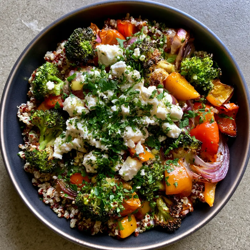 Close up of Roasted Vegetable Quinoa Salad showing the texture of fluffy white and red quinoa with charred green broccoli and red peppers.